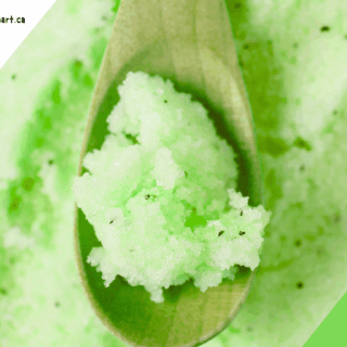 Cucumber mint green sugar scrub on a wooden spoon