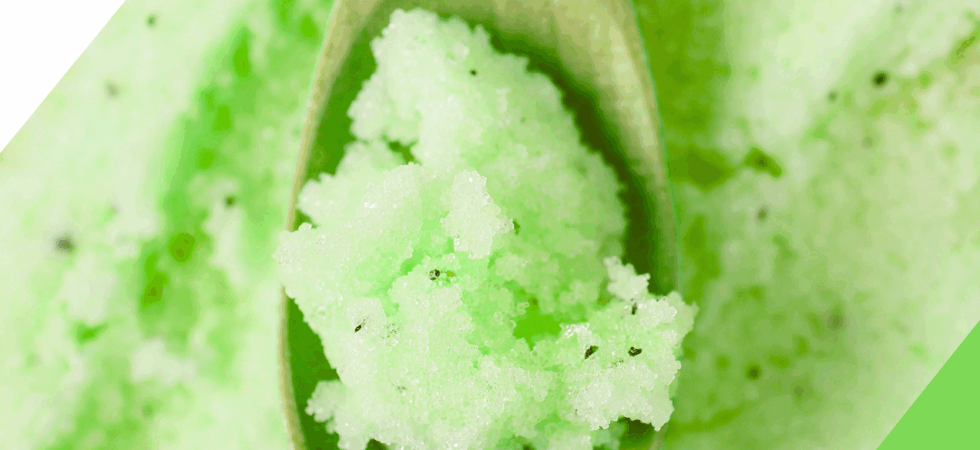 Cucumber mint green sugar scrub on a wooden spoon