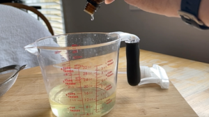 Adding essential oils to our vinegar and extracted orange mixture 