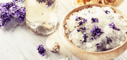 bowl of lavender bath soak with a glass of lavender essential oil