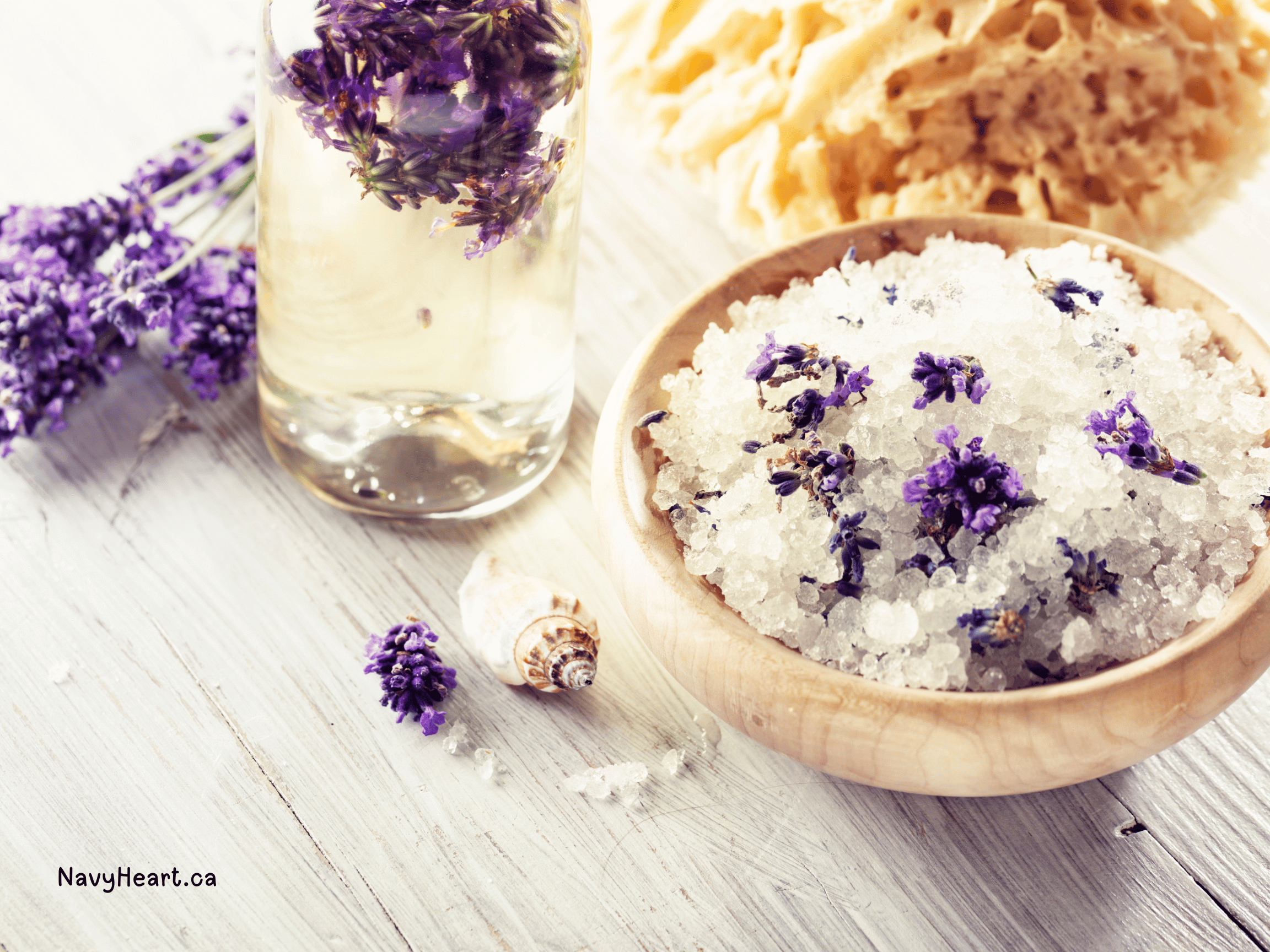 bowl of lavender bath soak with a glass of lavender essential oil